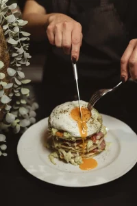 033 menu - coktail photos φωτογράφιση πρωινού μενού pan ceik με αυγά και χέρια που κόβουν το αβγό.